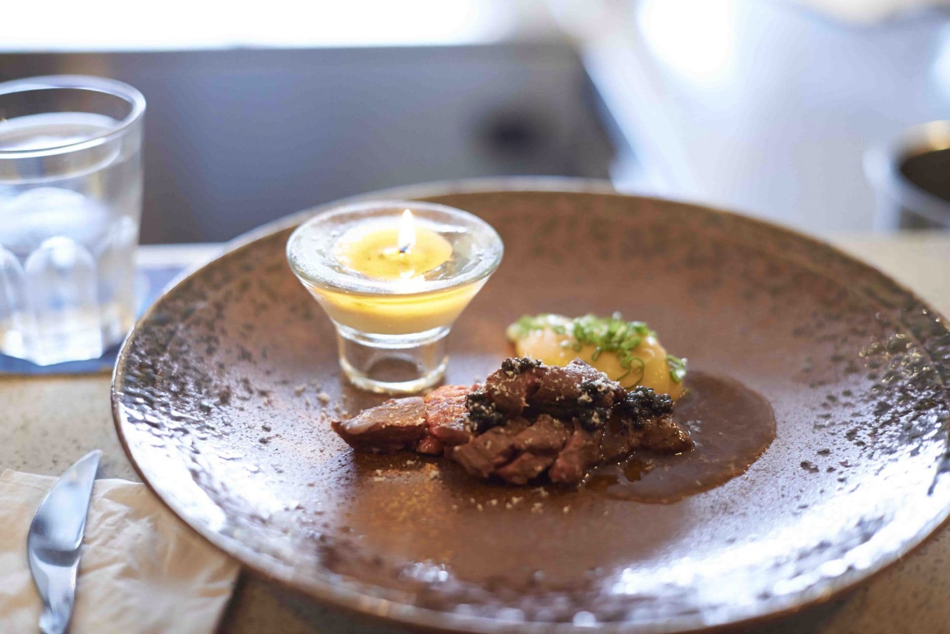 Charred beef onglet, onion mash, bordelaise candle